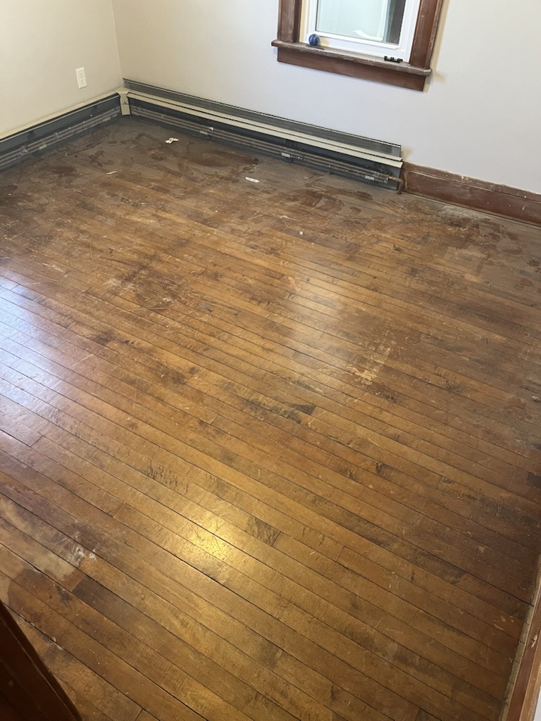Old damaged hardwood floor before restoration showing wear and scratches